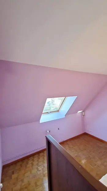 Chambre mansardée peinte en rose poudré, fenêtre de toit